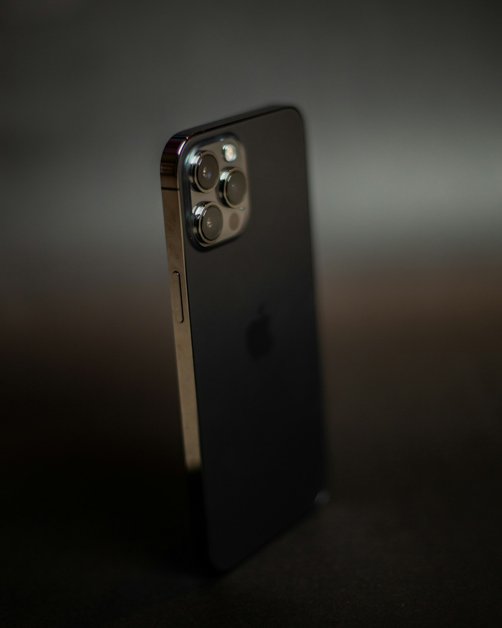 Black smartphone standing upright on a dark tabletop