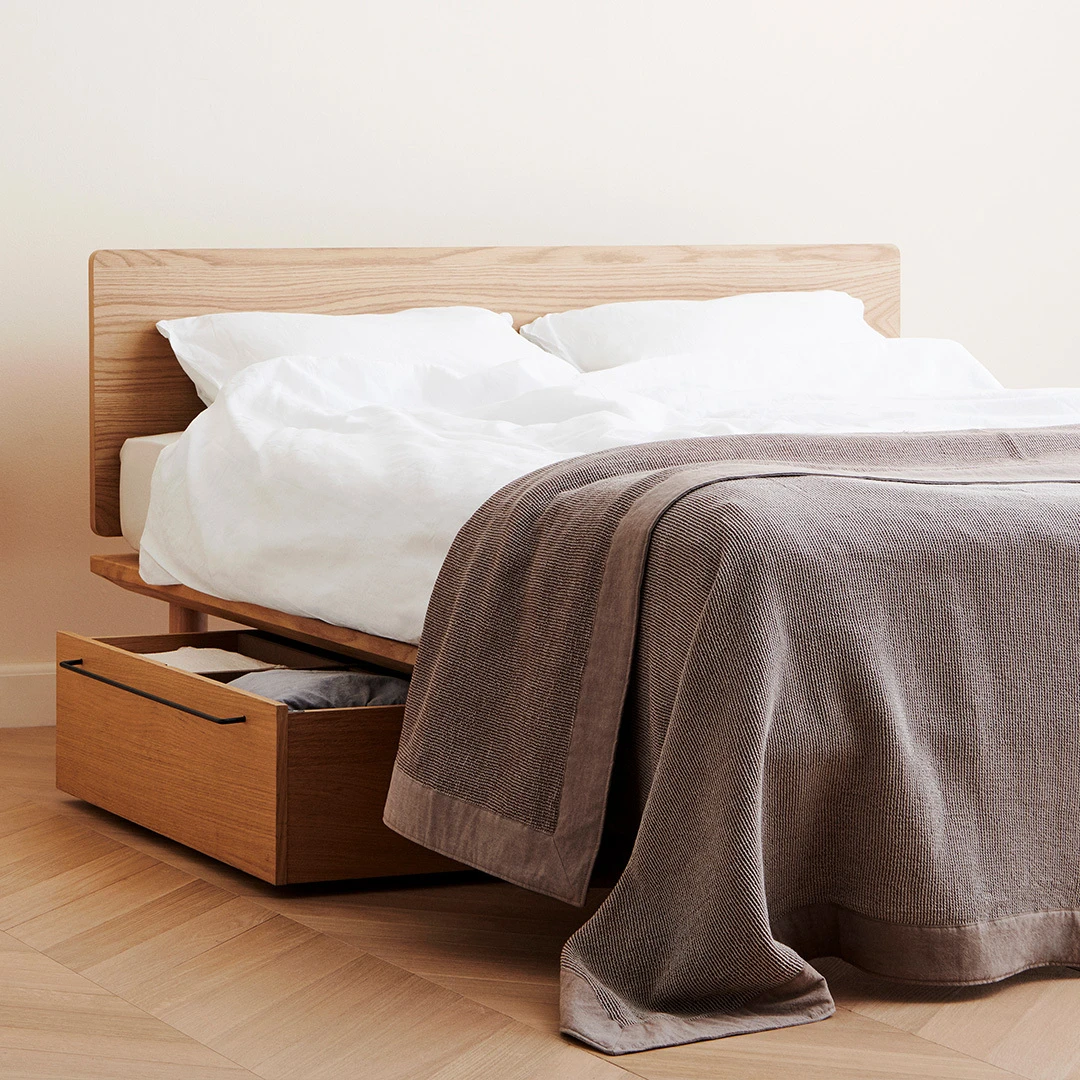 A calm MUJI bedroom with neutral bedding and simple furnishings