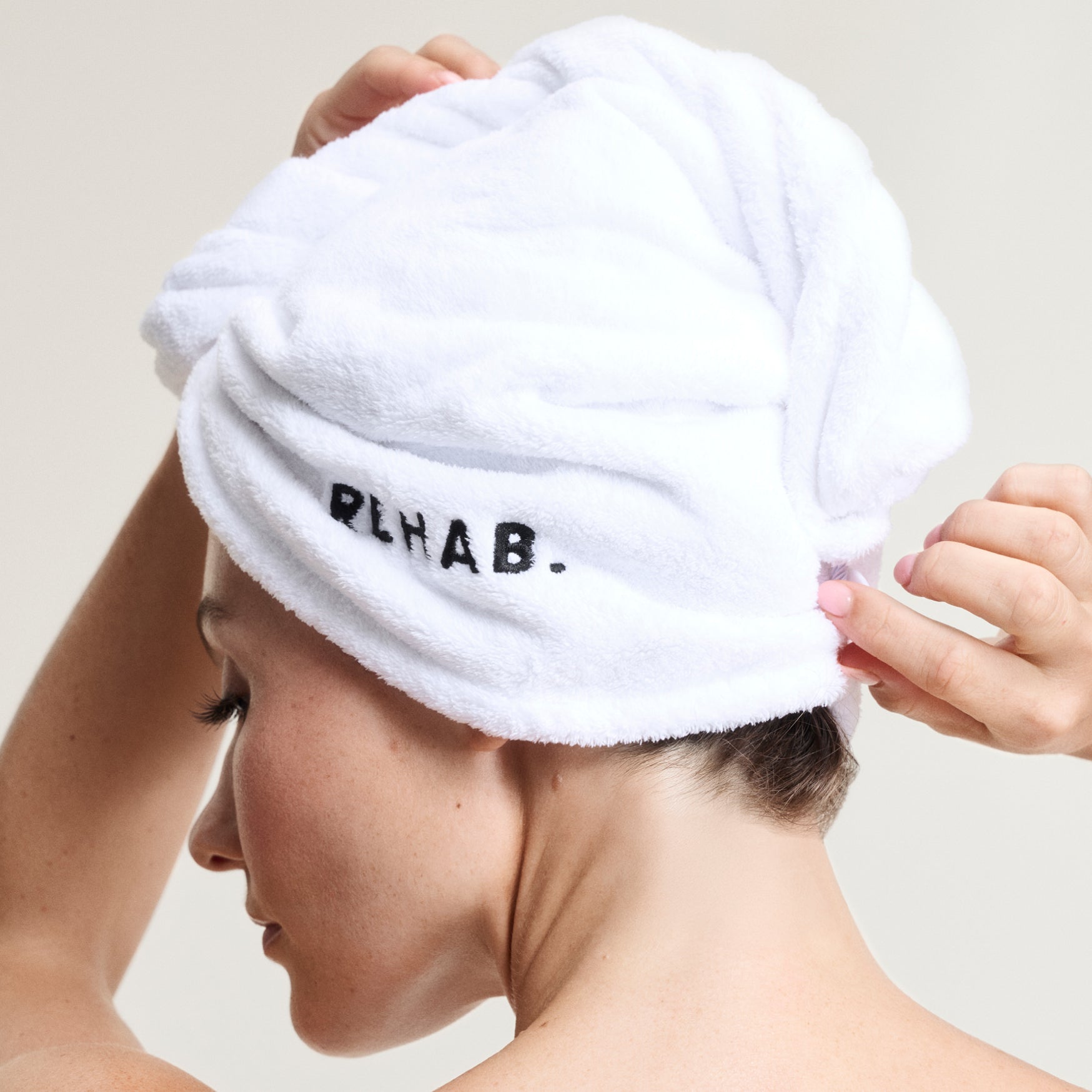 Woman wearing a towel turban as part of a hair-care routine