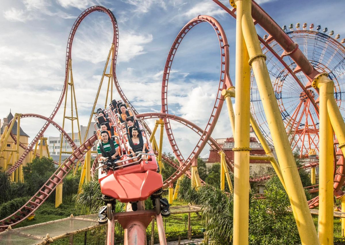 Riders on a looping roller coaster at an amusement park